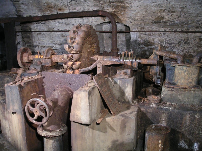 bs_comproom_pelton1.jpg - The pelton wheel in the compressor room. The pipe with the control valve is the water jet input to drive it. To the right of the pelton you have the reduction gear box housing, next to this the compressor would have been positioned, but it is missing.