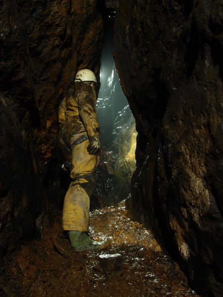 P3108395.JPG - Pete looking down from the level in the wet rise. The fine rubble cone can be seen here.