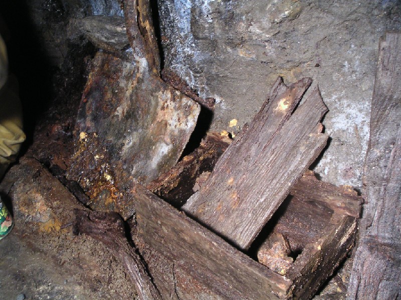 cc_woodenboxes.jpg - Wooden box with drill piece resting in the corner, along with a spade next to it.