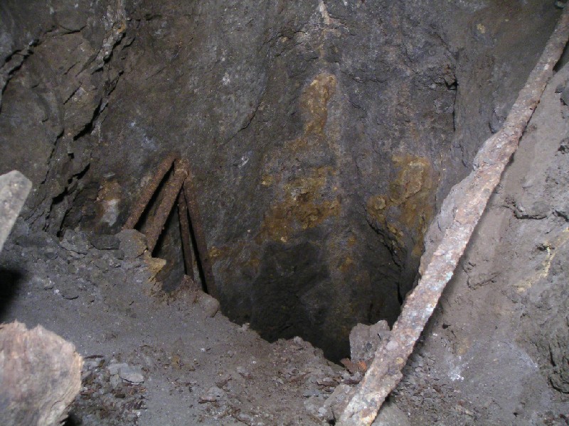cc_mcnv_stope_shaft1b.jpg - Looking down the shaft from the stope. The air pipes in the front go to a little ledge and then come out further in the shaft. To the left on the ledge there is an alcove with another shaft.
