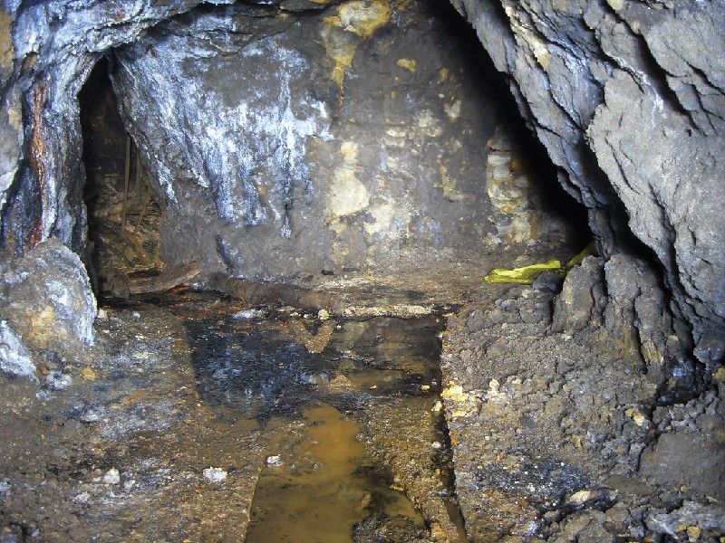 58_ccar_archerstope_eastjunc.jpg - Past the water and the first junction. In the left branch is the manway and chute which I think may well be an intersection with the bottom of the shaft near the toilet junction. The yellow is the Caving Supplies sack.