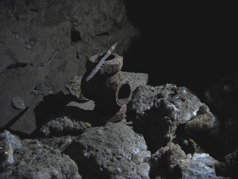 cc47_headingpassage_fittingandfile.jpg - Pipe fitting and triangular file, along with discarded mineral samples.