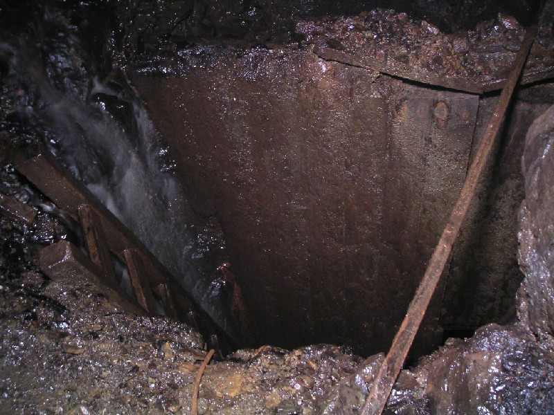 cch_levabove_cch_sump2.jpg - The top of the rise that we climbed to get into the sublevel above the Caplecleugh High Level. The water can be seen on the left behind the ladder.