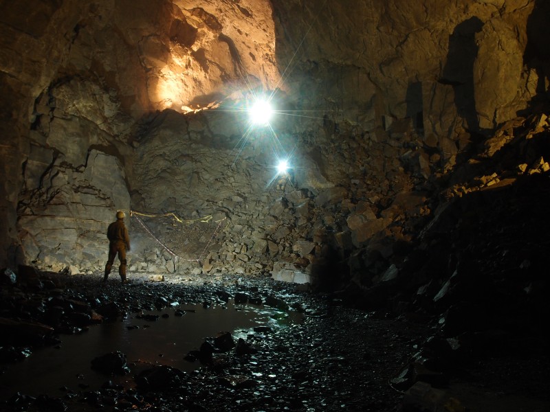 P8241461.JPG - East end of the main chamber. Myself and Pete climbing up. Photo by Karli.