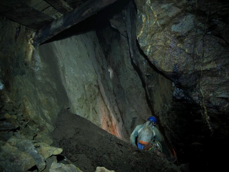 13_viewdownto3rdpitch17m.jpg - Top of the rubble slope near the Thriddle Shaft view point. The light from Pete's lamp (white glow in the middle of the snap) can be seen as he prepares to abseil down.