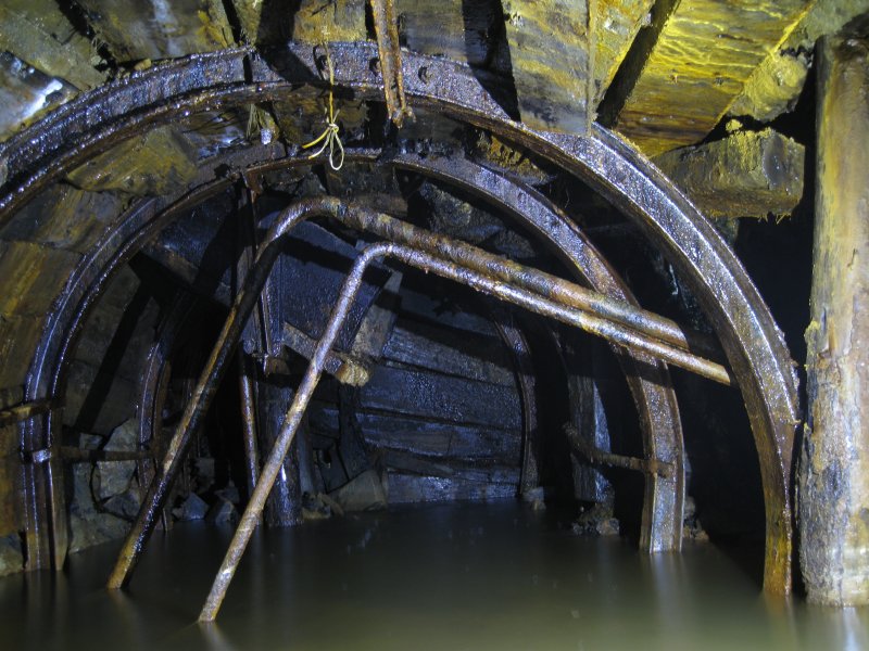 Img_3716.jpg - End of the steel arching in this section of level. The hopper is filled in and the level onwards sealed.
