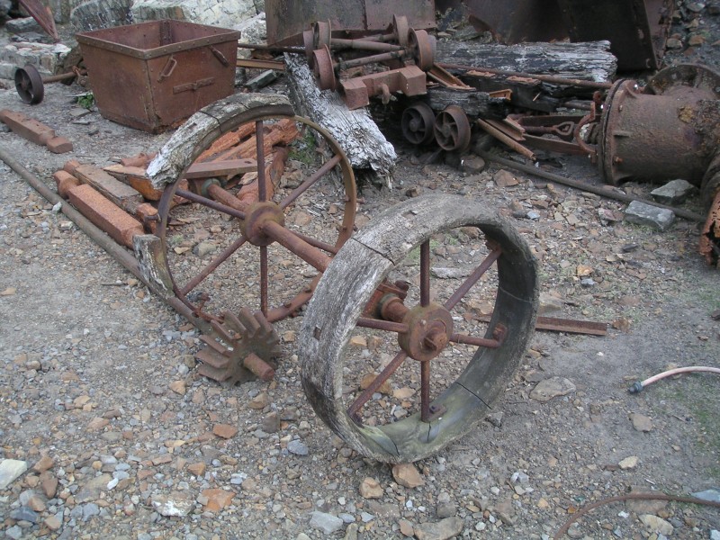 nsf_machinary06.jpg - Assortment of old machinery. Ore trucks in bits, pipe fittings and washer wheels.