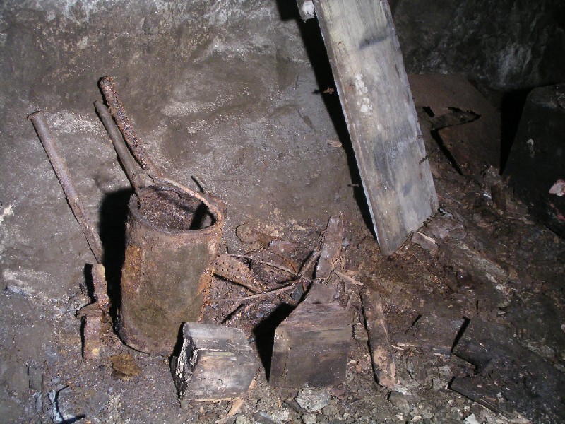 rg_rgshaft_engineroom4.jpg - More remains in the engine room, a selection of tools, a grease can, wooden blocks and the side or bottom of a wooden box.