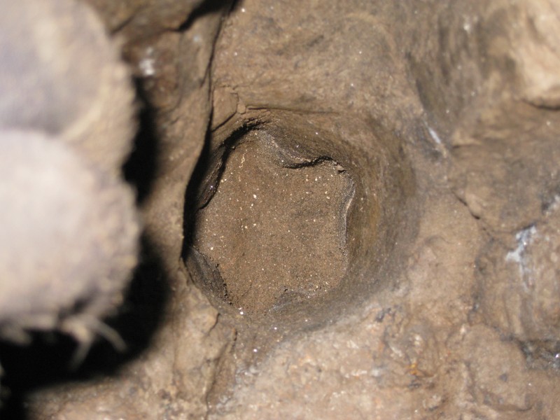 IMG_2676.jpg - Charge hole with star drill shape in the bottom. The blurred things on the left are by gloved up fingers.