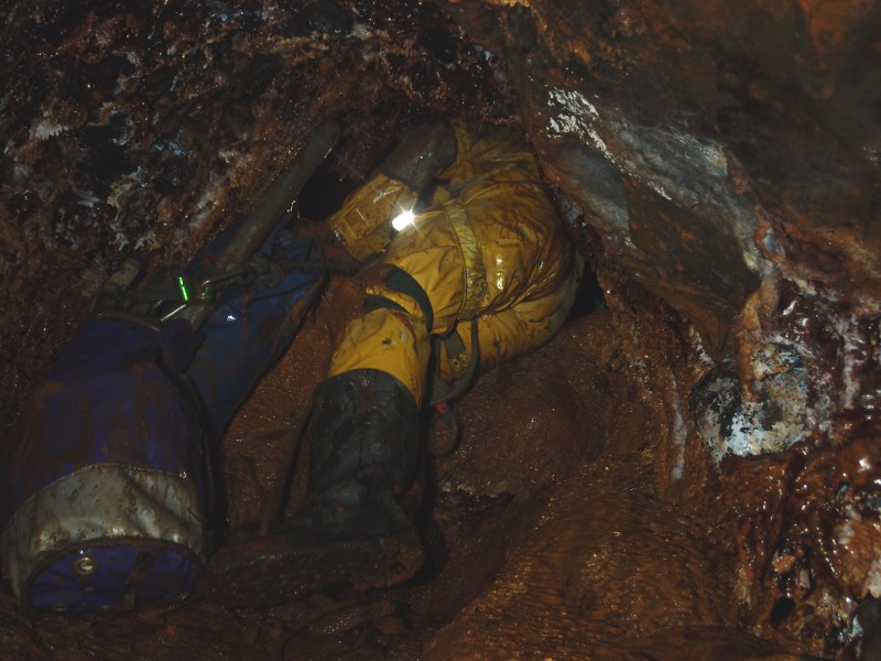 P8216647.jpg - Ian emerging from the sump into the first level.