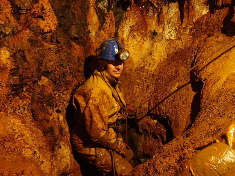 P8216666.JPG - Ian ready to abseil down the continuation of the sump from the horse level. All looking very orange.