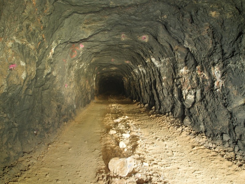 P6049370.JPG - Main access / haulage level. The white scrapes are where the scooptram keeps hitting the walls. Pink spray paint shows the shot holes for the widening of the level - when they have time.