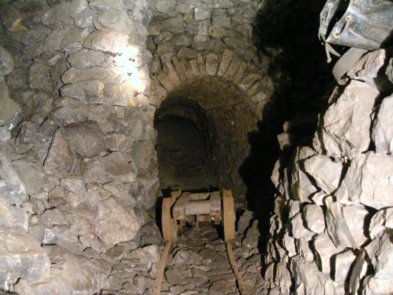 sc_boggie.jpg - Moving along after the drop you come to a large working which yet again has scope for further exploration. The boggie was a nice find and it does actually still go. Climbing up the deads on the left leads to a short passage.