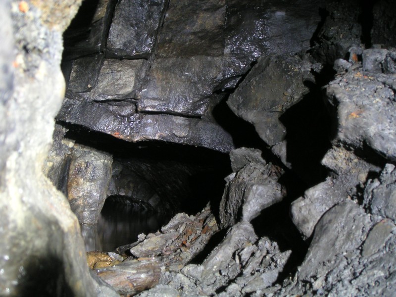 sc_2SVeast_collapse2.jpg - Looking into the collapse. The roof on the other side looks to be sound enough. You can see deep backed up water and the arching on the continuation of the passage in the background.