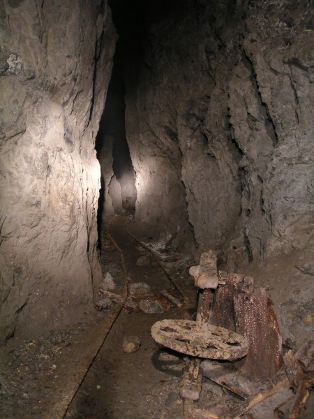 sc_sublevel1_stopes4.jpg - Looking to the west down the stope. A battered wheel barrow in the foreground and in the distance yet another ore truck.