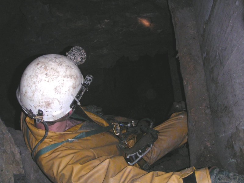 sc_desentdowntosublevel3.jpg - Karli climbing down the second small shaft. It is a double wooden lined one with a ladder. The drop is only around 3-4m.