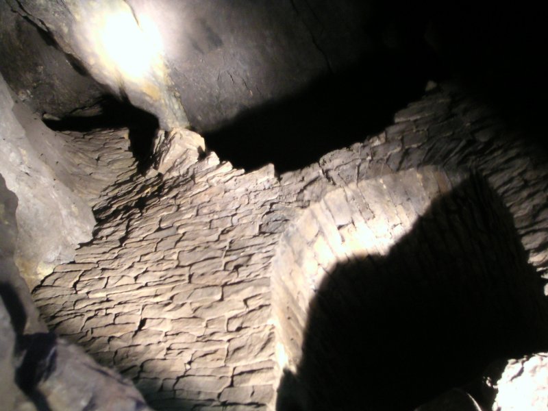 sc_sublevelcrossvein3.jpg - Looking up from the bottom of the chamber. The passage above the arch is where we came down from, we then noticed the pile of stones to the left that don't particulary look too great.