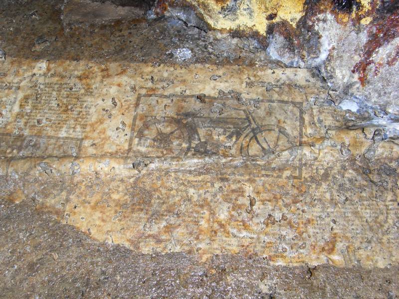 40_parallelv_archnewsp2.jpg - Newspapers on concrete arching, preserved by a thin layer of calcite. The paper is dated 24th november 1910 and the title of the page seems to be "The Motor Cycle", with a sub heading "Olympia Show".