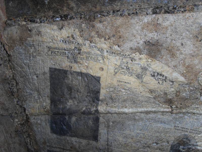 44_parallelv_archnewsp6.jpg - Newspapers on concrete arching, preserved by a thin layer of calcite. The Hexham Herald, Saturday..., the picture is the London Lord Mayor, under the heading of "Picture of the Week". To the right are sport related articles.