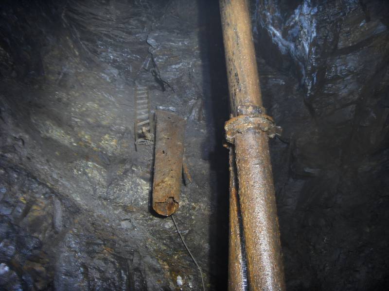 63_bogsh_pipes_cch.jpg - The ladder top brings you into a chamber some 4m below Caplecleugh High Level, that is at the top of the ladder in background. This is the route now to the other side of Bogg Shaft.