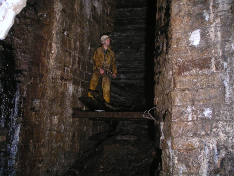 sc_barronsump_22m_viwfromlev_karli.jpg - The large alcove with timber remains. Bands of shale can be seen in the background.