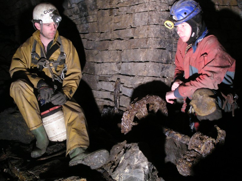 sc_xvein_subsublevel_artifacts1.jpg - A solemn photograph of us contemplating the remains. This is in the second sublevel just in from the chamber we came into from the Letter Box sump.