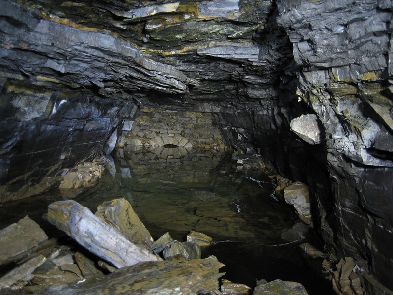 IMG_4735.JPG - The end of the shale fall and the sumped up passage. Nice reflection in the water.