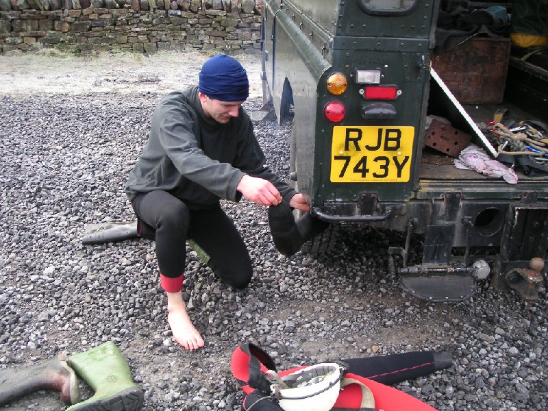 de_icing_wetsocks.jpg - A professional start, Karli de-icing his frozen wetsocks on the exhaust.