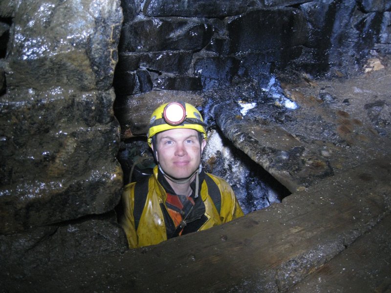 15_sublevelcalrise-pete-11-29.jpg - 11:29: The start of warmer climes, Sub Level at the top of the Double Rise, below Smallcleugh. Pete popping out the hole.