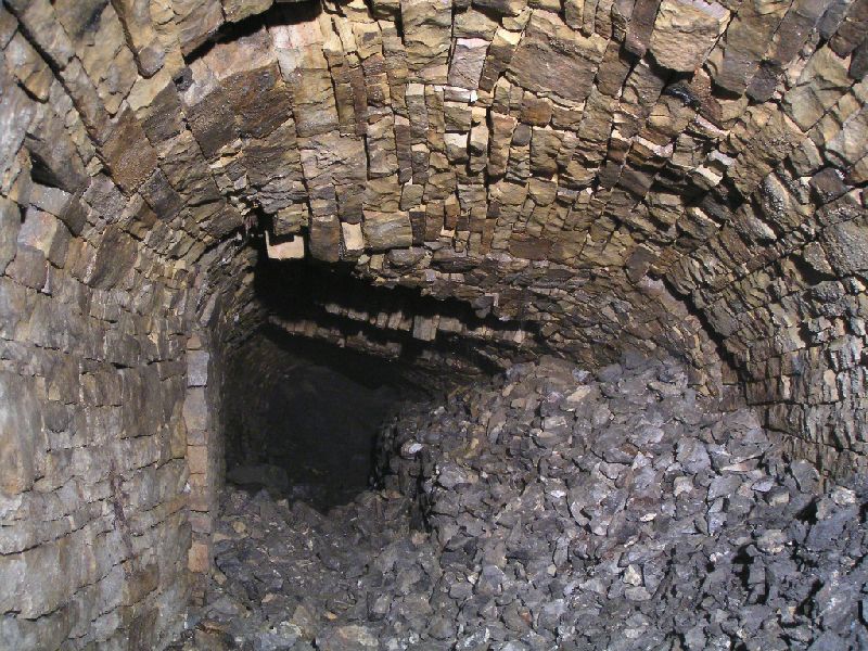 cl_passage_proudswall.jpg - The passage just past the Proud's wall. The roof arching here is almost horizontal and has collapsed in a few places. Thankfully there seems to be a plain about 30cm above it, so any further collapses should not seal you in!