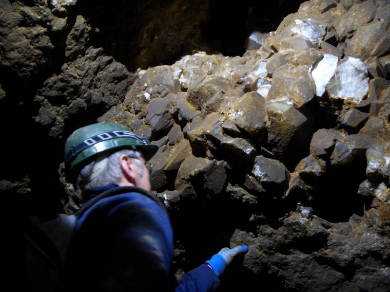 32_wp_don_calcitenearstreampass.jpg - In the maze, a fine pocket of calcite, including a dog's tooth just to the right of Don's head.